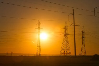 Yüksek gerilim enerji nakil hattı. Enerji ayağı. Gün batımı, şafakta. Elektrik