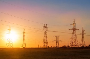 Yüksek gerilim enerji nakil hattı. Enerji ayağı. Gün batımı, şafakta. Elektrik