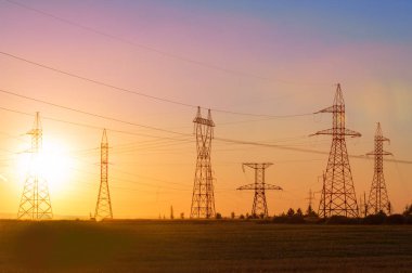 Yüksek gerilim enerji nakil hattı. Enerji ayağı. Gün batımı, şafakta. Elektrik