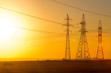 Yüksek gerilim enerji nakil hattı. Enerji ayağı. Gün batımı, şafakta. Elektrik