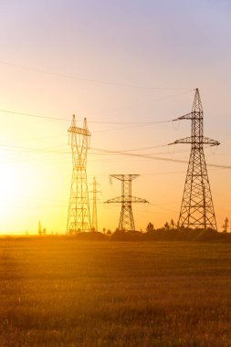 Yüksek gerilim enerji nakil hattı. Enerji ayağı. Gün batımı, şafakta. Elektrik