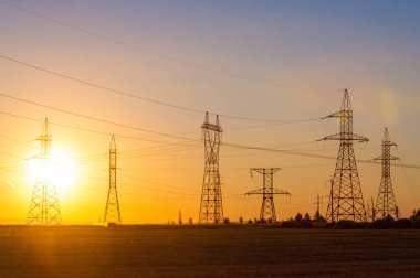 Yüksek gerilim enerji nakil hattı. Enerji ayağı. Gün batımı, şafakta. Elektrik