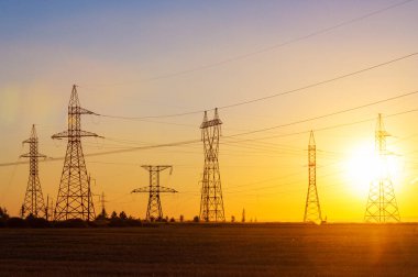 Yüksek gerilim enerji nakil hattı. Enerji ayağı. Gün batımı, şafakta. Elektrik