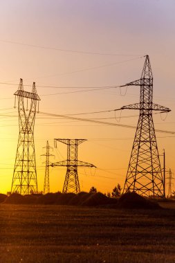 Yüksek gerilim enerji nakil hattı. Enerji ayağı. Gün batımı, şafakta. Elektrik