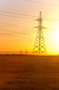 Yüksek gerilim enerji nakil hattı. Enerji ayağı. Gün batımı, şafakta. Elektrik
