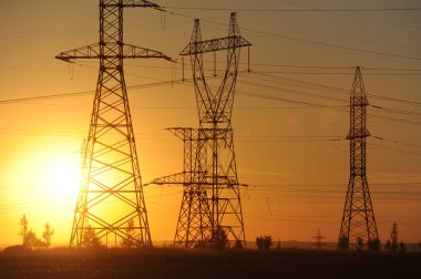 Yüksek gerilim enerji nakil hattı. Enerji ayağı. Gün batımı, şafakta. Elektrik
