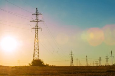 Yüksek gerilim enerji nakil hattı. Enerji ayağı. Gün batımı, şafakta. Elektrik