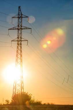 Yüksek gerilim enerji nakil hattı. Enerji ayağı. Gün batımı, şafakta. Elektrik