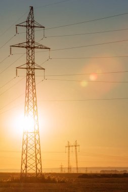 Yüksek gerilim enerji nakil hattı. Enerji ayağı. Gün batımı, şafakta. Elektrik
