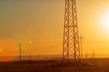 Yüksek gerilim enerji nakil hattı. Enerji ayağı. Gün batımı, şafakta. Elektrik