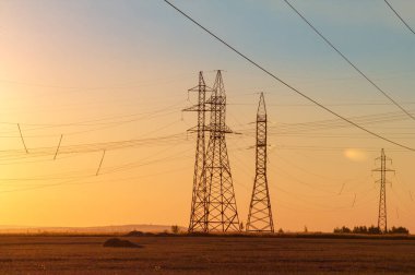 Yüksek gerilim enerji nakil hattı. Enerji ayağı. Gün batımı, şafakta. Elektrik