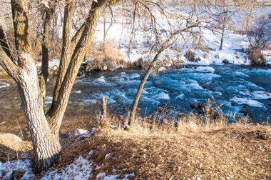 su küçük bir nehir erken ilkbahar akarsu. Bahar sahne. donmuş bir dere ile dağ manzarası