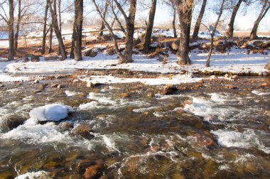 su küçük bir nehir erken ilkbahar akarsu. Bahar sahne. donmuş bir dere ile dağ manzarası
