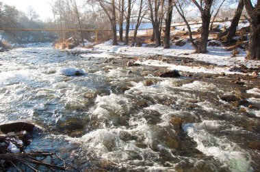 su küçük bir nehir erken ilkbahar akarsu. Bahar sahne. donmuş bir dere ile dağ manzarası