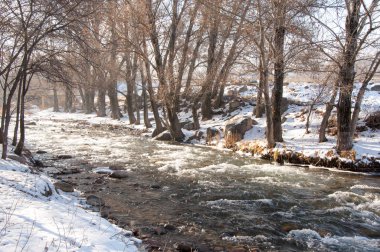 su küçük bir nehir erken ilkbahar akarsu. Bahar sahne. donmuş bir dere ile dağ manzarası