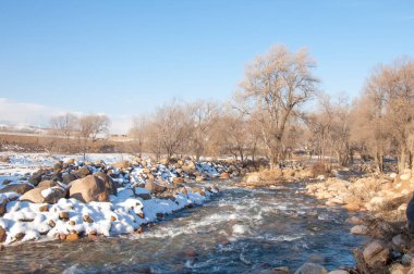 su küçük bir nehir erken ilkbahar akarsu. Bahar sahne. donmuş bir dere ile dağ manzarası