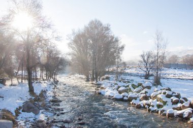 su küçük bir nehir erken ilkbahar akarsu. Bahar sahne. donmuş bir dere ile dağ manzarası