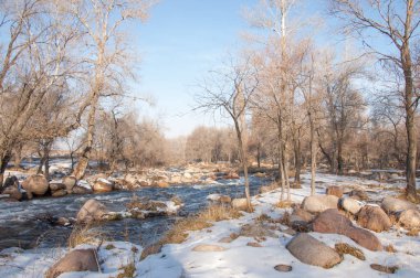 su küçük bir nehir erken ilkbahar akarsu. Bahar sahne. donmuş bir dere ile dağ manzarası