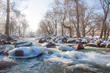 su küçük bir nehir erken ilkbahar akarsu. Bahar sahne. donmuş bir dere ile dağ manzarası