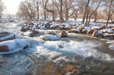 su küçük bir nehir erken ilkbahar akarsu. Bahar sahne. donmuş bir dere ile dağ manzarası