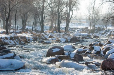 su küçük bir nehir erken ilkbahar akarsu. Bahar sahne. donmuş bir dere ile dağ manzarası