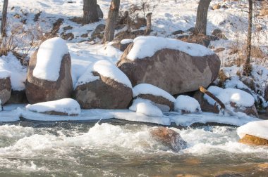 su küçük bir nehir erken ilkbahar akarsu. Bahar sahne. donmuş bir dere ile dağ manzarası