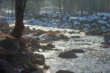 su küçük bir nehir erken ilkbahar akarsu. Bahar sahne. donmuş bir dere ile dağ manzarası
