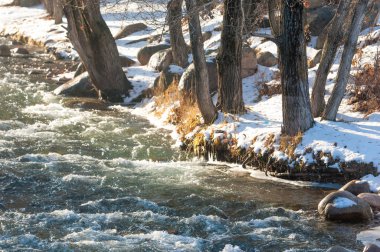 su küçük bir nehir erken ilkbahar akarsu. Bahar sahne. donmuş bir dere ile dağ manzarası