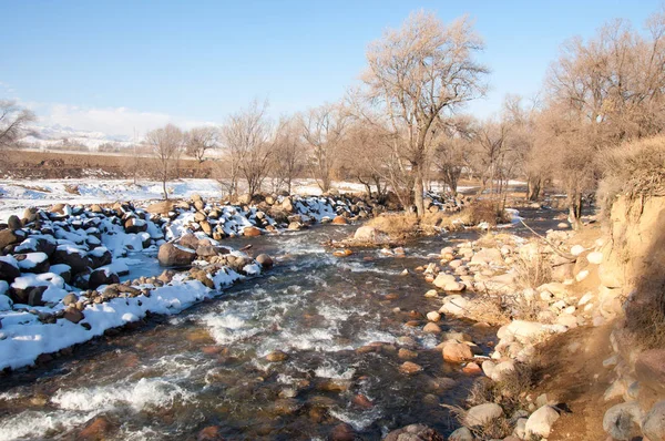 su küçük bir nehir erken ilkbahar akarsu. Bahar sahne. donmuş bir dere ile dağ manzarası