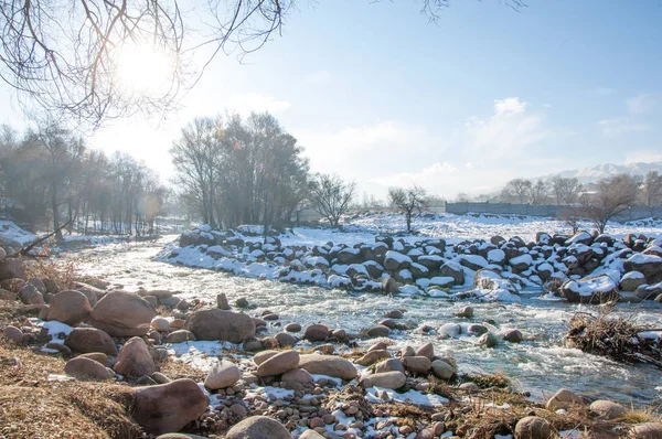 su küçük bir nehir erken ilkbahar akarsu. Bahar sahne. donmuş bir dere ile dağ manzarası