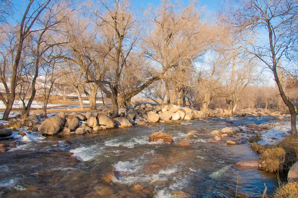 su küçük bir nehir erken ilkbahar akarsu. Bahar sahne. donmuş bir dere ile dağ manzarası
