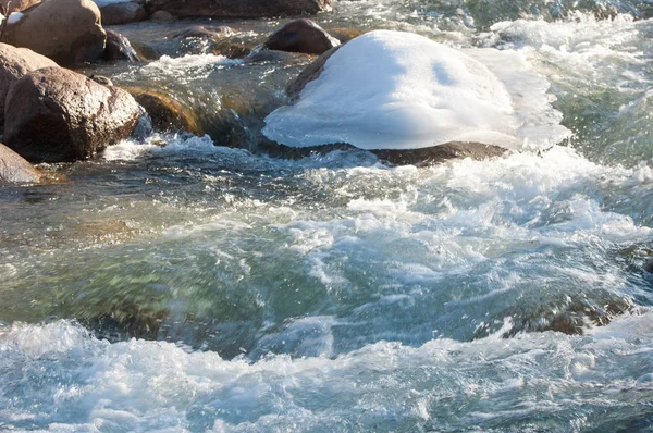 su küçük bir nehir erken ilkbahar akarsu. Bahar sahne. donmuş bir dere ile dağ manzarası