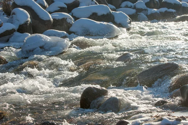 su küçük bir nehir erken ilkbahar akarsu. Bahar sahne. donmuş bir dere ile dağ manzarası