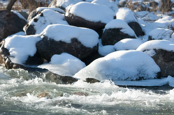 su küçük bir nehir erken ilkbahar akarsu. Bahar sahne. donmuş bir dere ile dağ manzarası