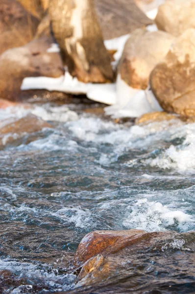 su küçük bir nehir erken ilkbahar akarsu. Bahar sahne. donmuş bir dere ile dağ manzarası