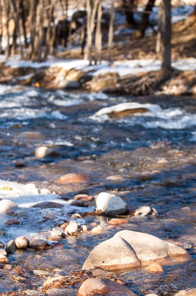 su küçük bir nehir erken ilkbahar akarsu. Bahar sahne. donmuş bir dere ile dağ manzarası