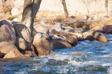 su küçük bir nehir erken ilkbahar akarsu. Bahar sahne. donmuş bir dere ile dağ manzarası