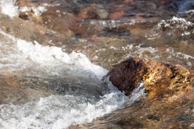 su küçük bir nehir erken ilkbahar akarsu. Bahar sahne. donmuş bir dere ile dağ manzarası