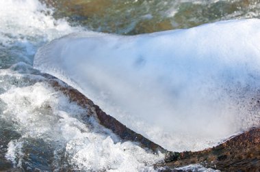 su küçük bir nehir erken ilkbahar akarsu. Bahar sahne. donmuş bir dere ile dağ manzarası
