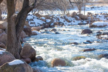 su küçük bir nehir erken ilkbahar akarsu. Bahar sahne. donmuş bir dere ile dağ manzarası