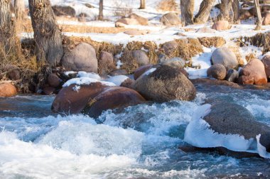 su küçük bir nehir erken ilkbahar akarsu. Bahar sahne. donmuş bir dere ile dağ manzarası