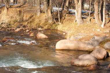 su küçük bir nehir erken ilkbahar akarsu. Bahar sahne. donmuş bir dere ile dağ manzarası