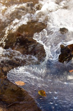 su küçük bir nehir erken ilkbahar akarsu. Bahar sahne. donmuş bir dere ile dağ manzarası