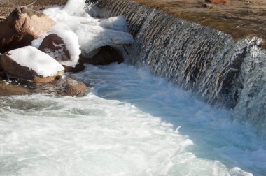 su küçük bir nehir erken ilkbahar akarsu. Bahar sahne. donmuş bir dere ile dağ manzarası
