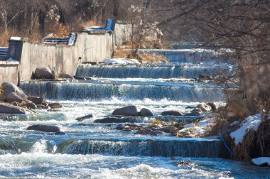 su küçük bir nehir erken ilkbahar akarsu. Bahar sahne. donmuş bir dere ile dağ manzarası