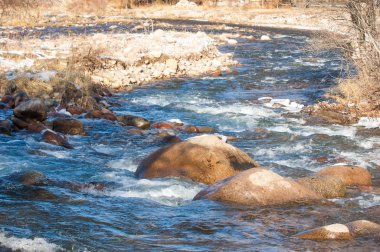 su küçük bir nehir erken ilkbahar akarsu. Bahar sahne. donmuş bir dere ile dağ manzarası