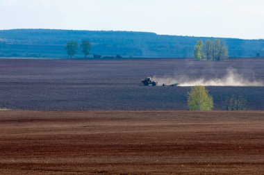 Alan sürülmüş, ekilen hububat. Bahar günü sürülmüş alana. Siyah toprak sürülmüş alan. Mavi gökyüzünde sürülmüş alan