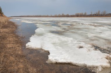 Bahar River, buz Nehri üzerinde. çıplak ağaçlar ve mavi gökyüzünde güzel bulutlar güzel bahar manzara nehir buz ile erimiş