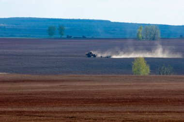 Alan sürülmüş, ekilen hububat. Bahar günü sürülmüş alana. Siyah toprak sürülmüş alan. Mavi gökyüzünde sürülmüş alan