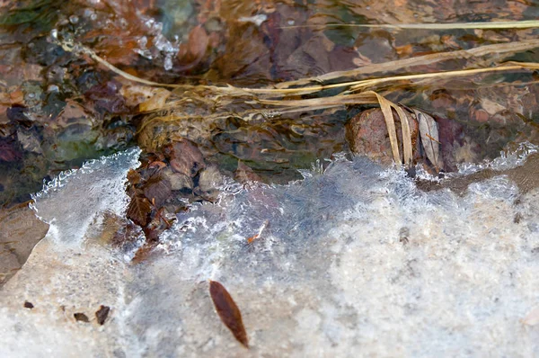 su küçük bir nehir erken ilkbahar akarsu. Bahar sahne. donmuş bir dere ile dağ manzarası